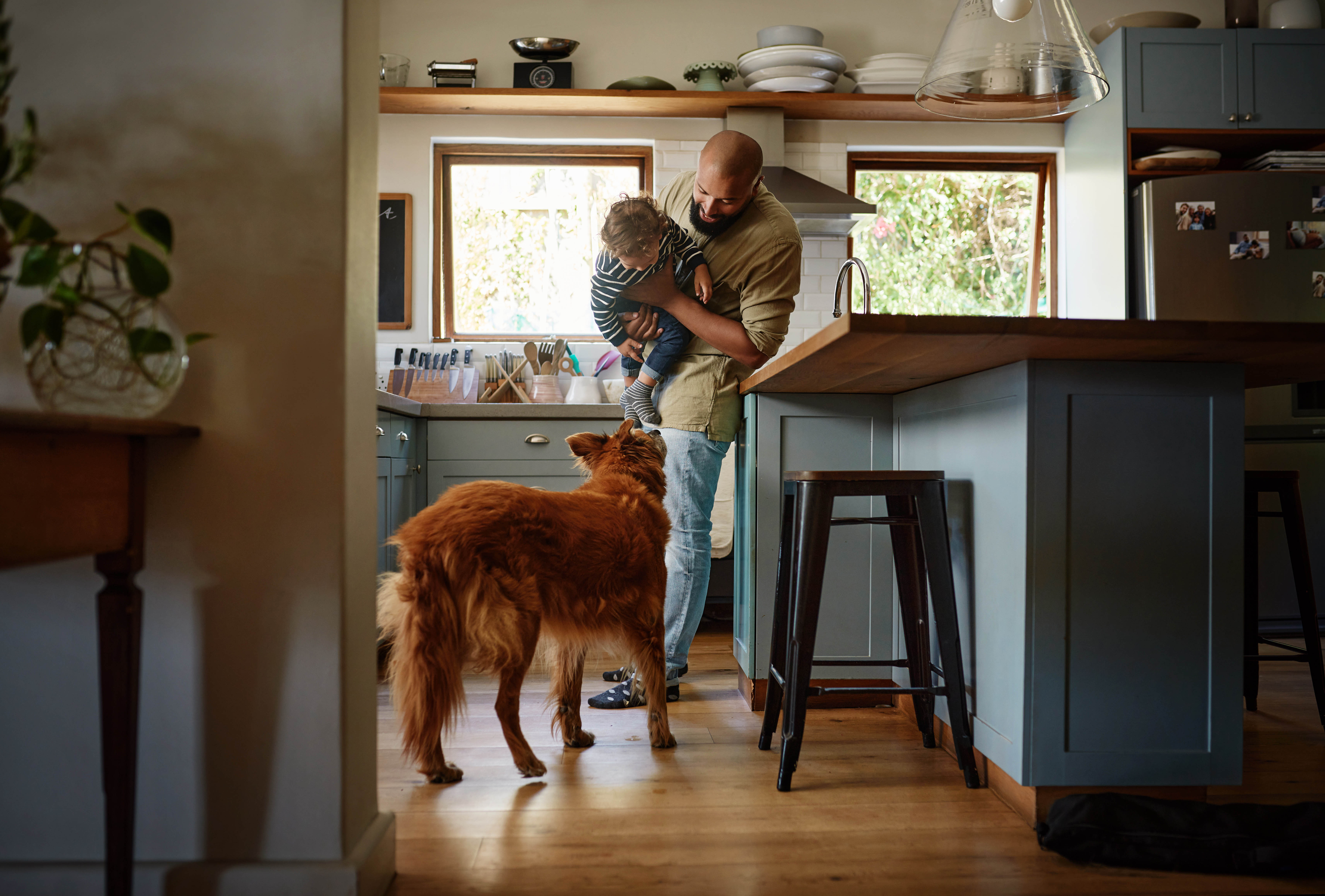 man in his home with young child and dog